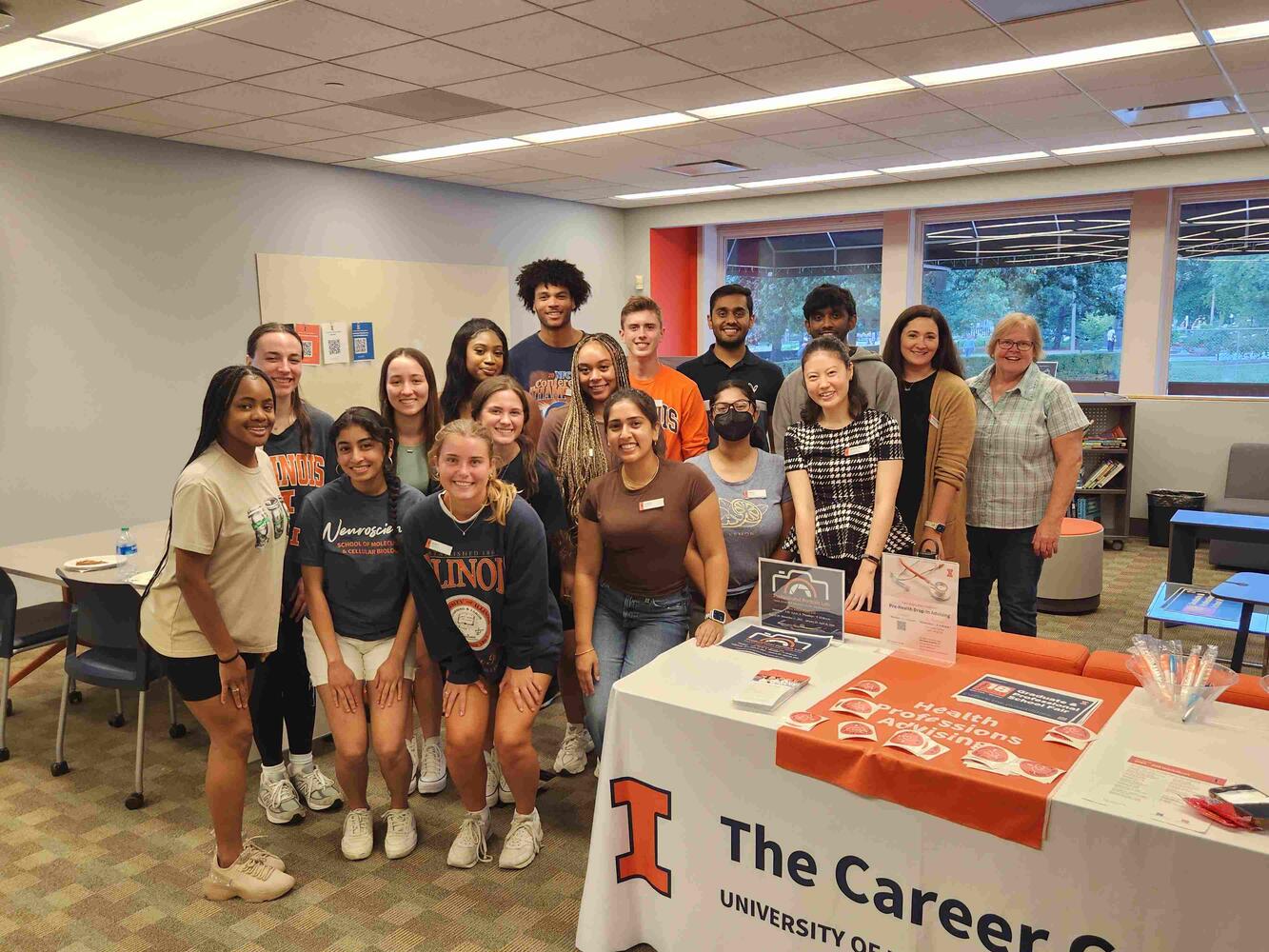A group of students (pre-health ambassadors) posing with in illini gear with Health Career Advisors