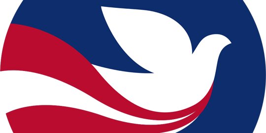 Peace Corps logo of a white dove on a blue circular background with red and white stripes below it