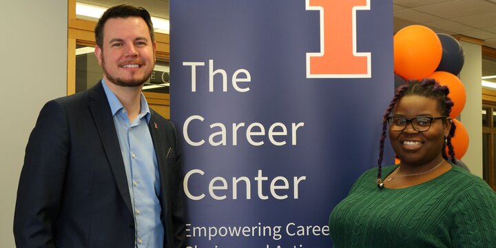 two career coaches pose with a Career Center sign